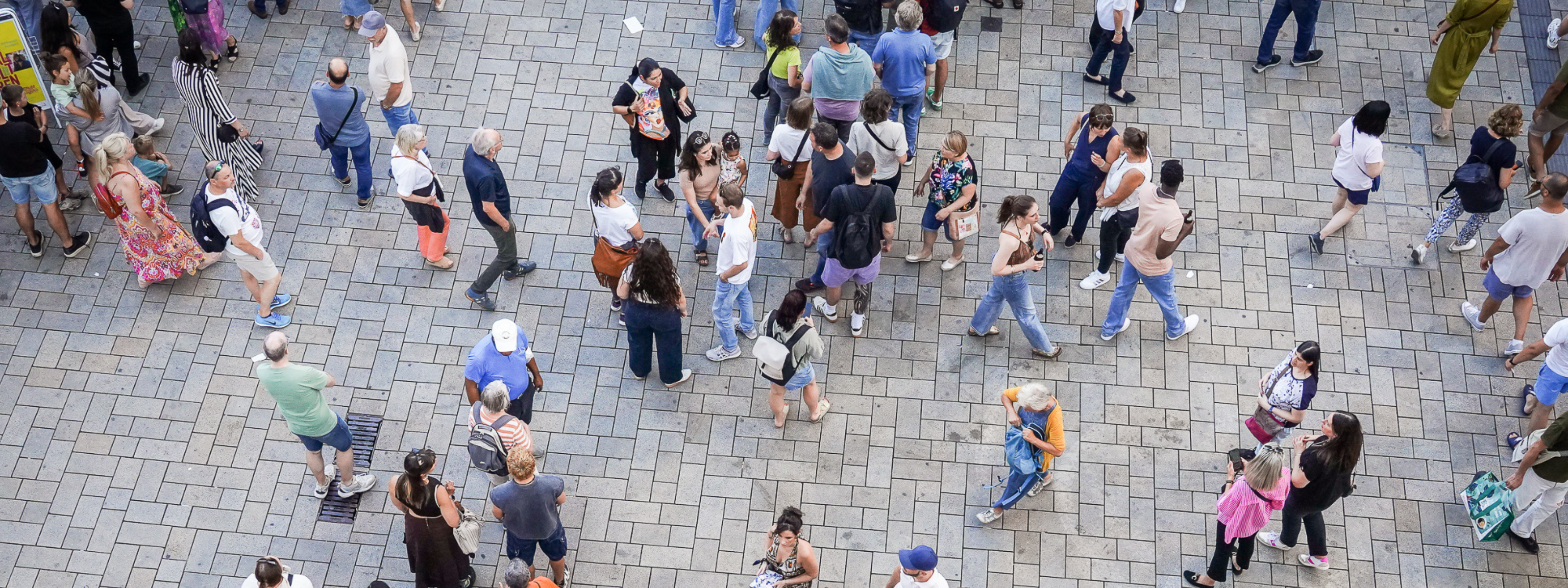 Das Bild zeigt mehrere Menschen auf dem Marktplatz Stuttgart. Das Bild wurde von oben aufgenommen und zeigt die Szene aus der Vogelperspektive.
